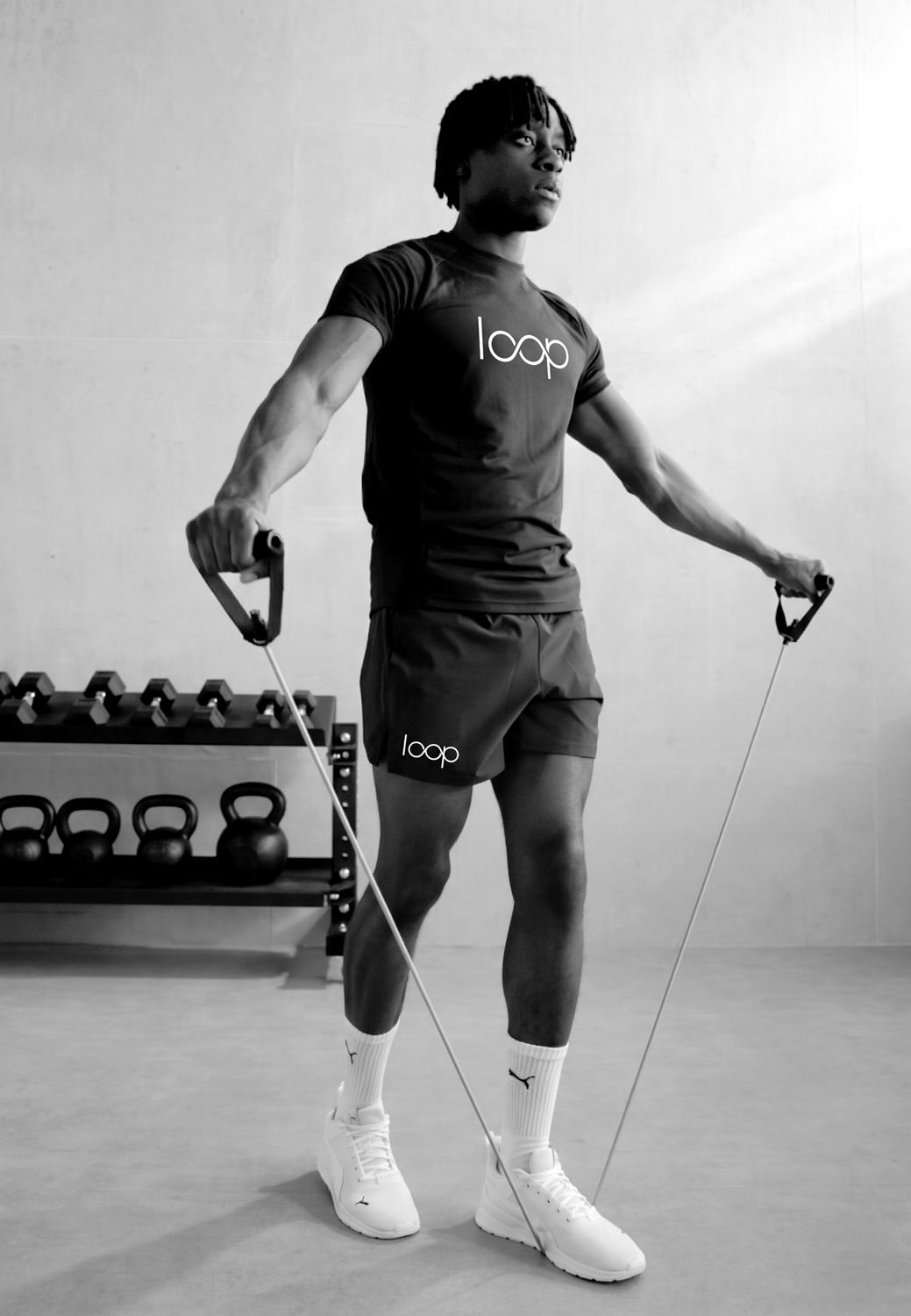 Athlete training with resistance bands in a black Loop tee and shorts